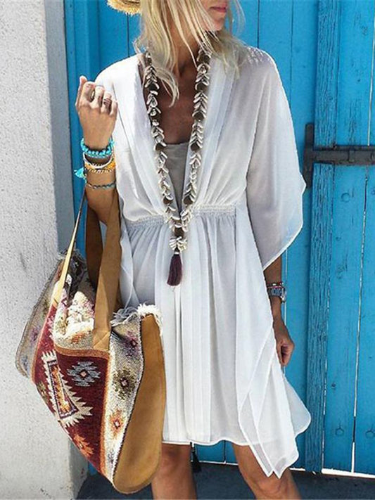 Dameszomerjurk met asymmetrische snit voor op het strand