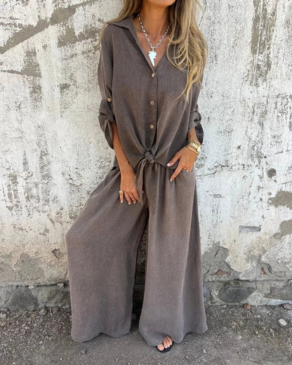 Elegante dameszomeroutfit met wijde broek en knoopblouse met lange mouwen